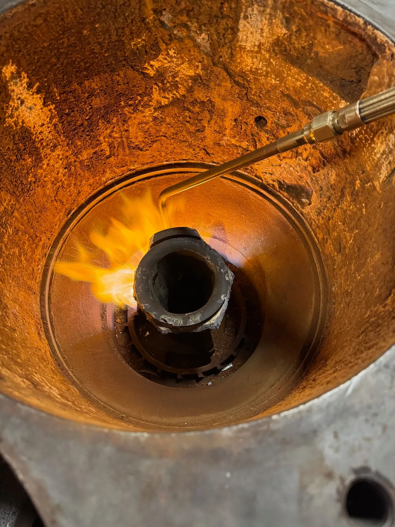 Torch being applied inside a badly corroded centrifugal compressor bore to heat-release a stuck bearing race during disassembly