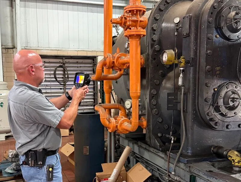 Fischer Group technician scanning a centrifugal compressor with a thermal imaging camera