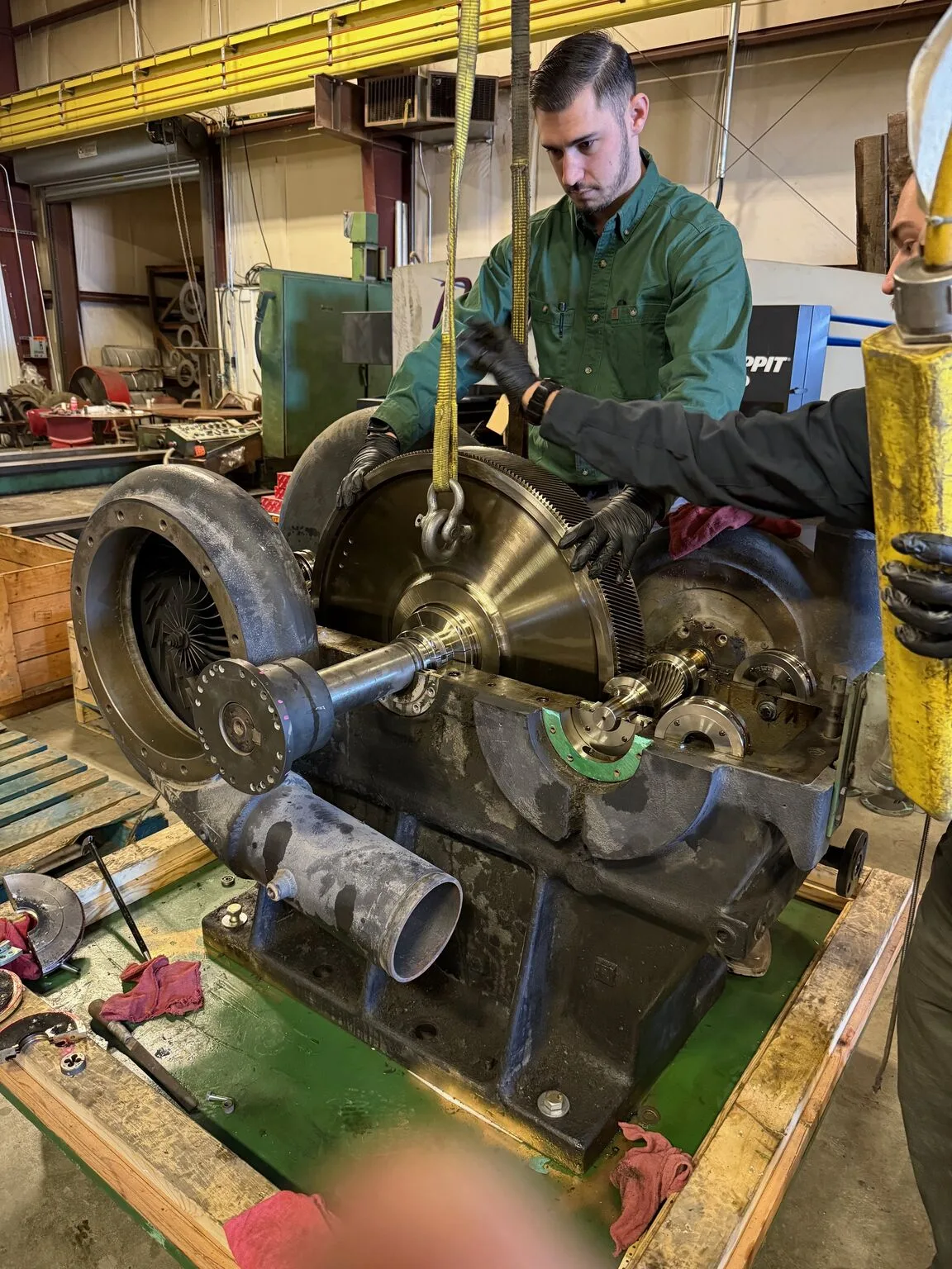 Fischer Group technician rigging the bull gear and pinion out of a Joy TA-50 centrifugal compressor during a rebuild