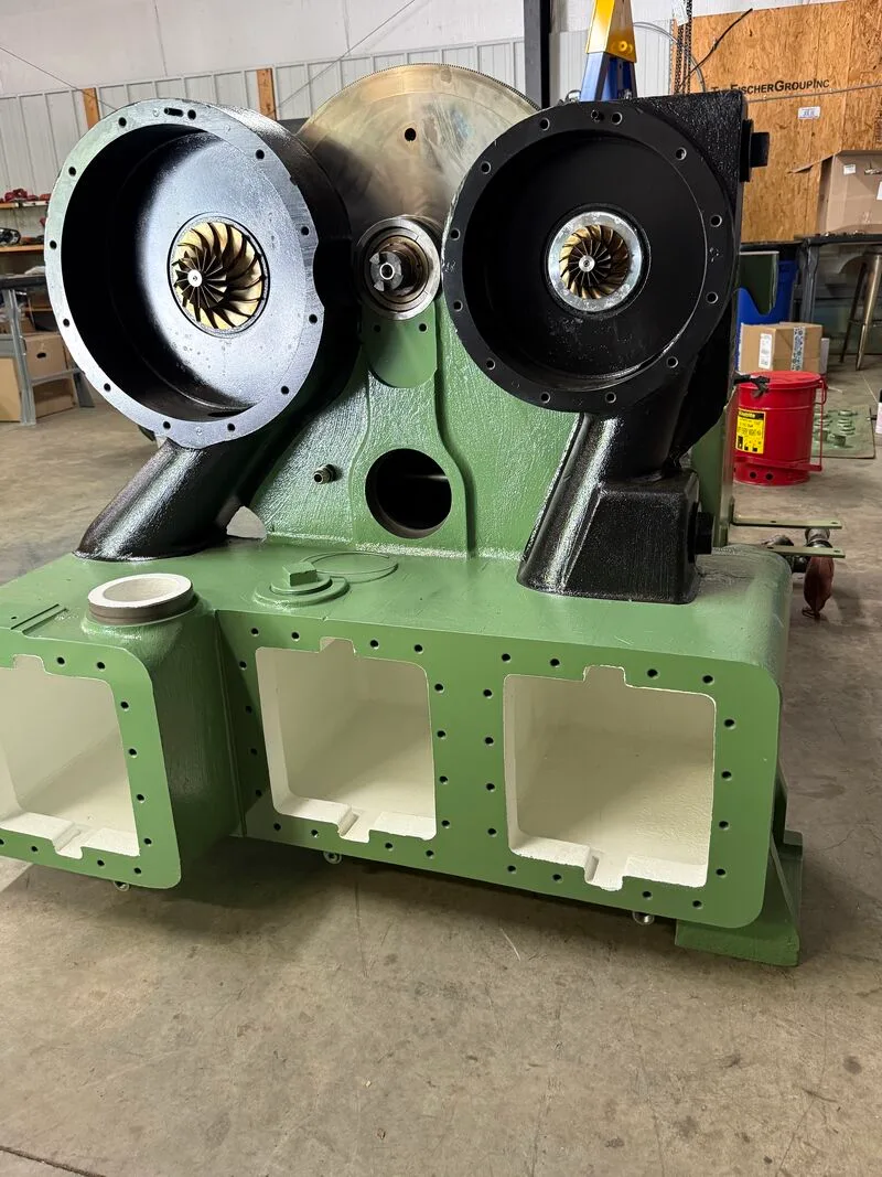 Rebuilt centrifugal compressor in fresh paint on the Fischer Group shop floor, with both stage housings open