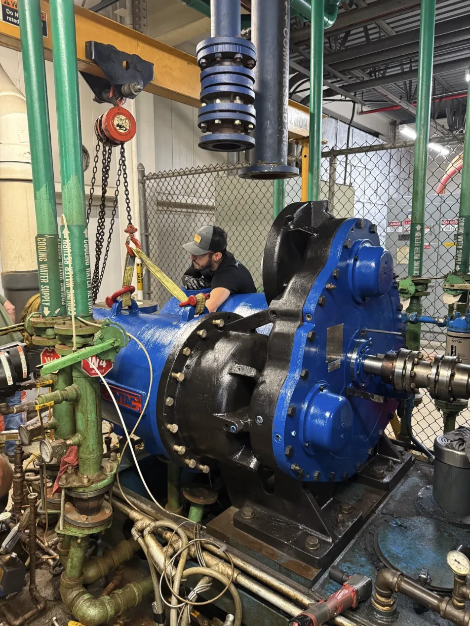 Fischer Group technicians setting a spare gear-case assembly on a matched centrifugal compressor